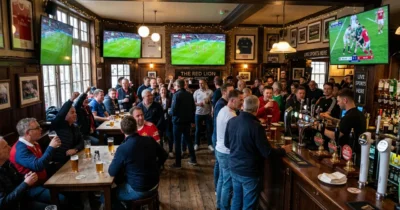 Traditional British sports pub with multiple wall-mounted 4K screens broadcasting live sports matches